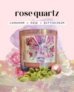 the rose quartz candle is pictured in pink, iridescent glass featuring a label with a dynamic pink collage of a woman's face surrounded by florals and gemstones. the candle is surrounded by a rose quartz stone, a pink pearl, cardamom pods, a dollop of buttercream, and pink roses. the scent notes read "cardamom + rose + buttercream"